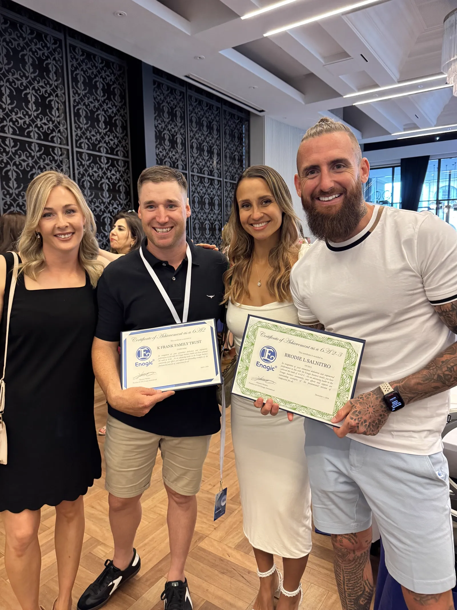 Brodie Salnitro holding his Enagic 6A2-3 Certificate of Achievement beside team members at an Enagic event
